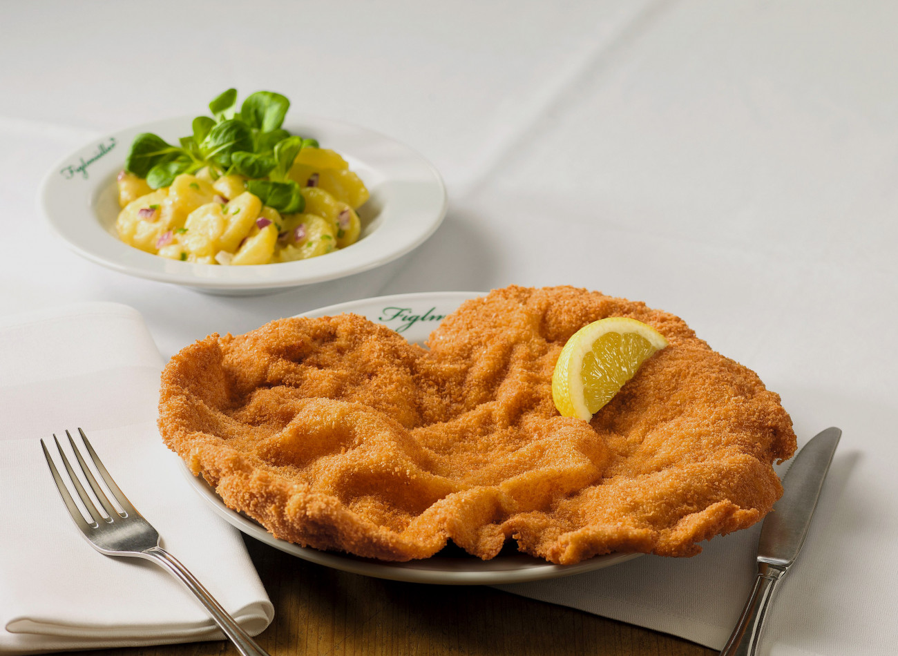 Das originale Figlmüller Wiener Schnitzel - serviert mit Zitrone und Kartoffelsalat.