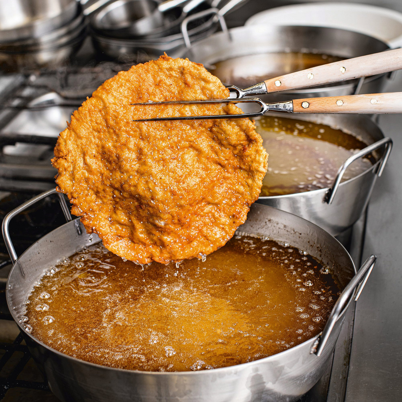 Figlmüller Wiener Schnitzel wird aus dem Fett gehoben.