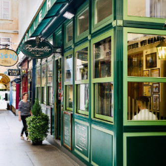 Straßenansicht des Restaurants Figlmüller in der Wollzeile mit grüner Fensterfront und Schild.