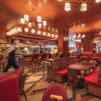 Café am Dom Wien – Bar und Restaurant-Innenraum mit roter Lounge, Mosaikboden und beleuchteter Theke.